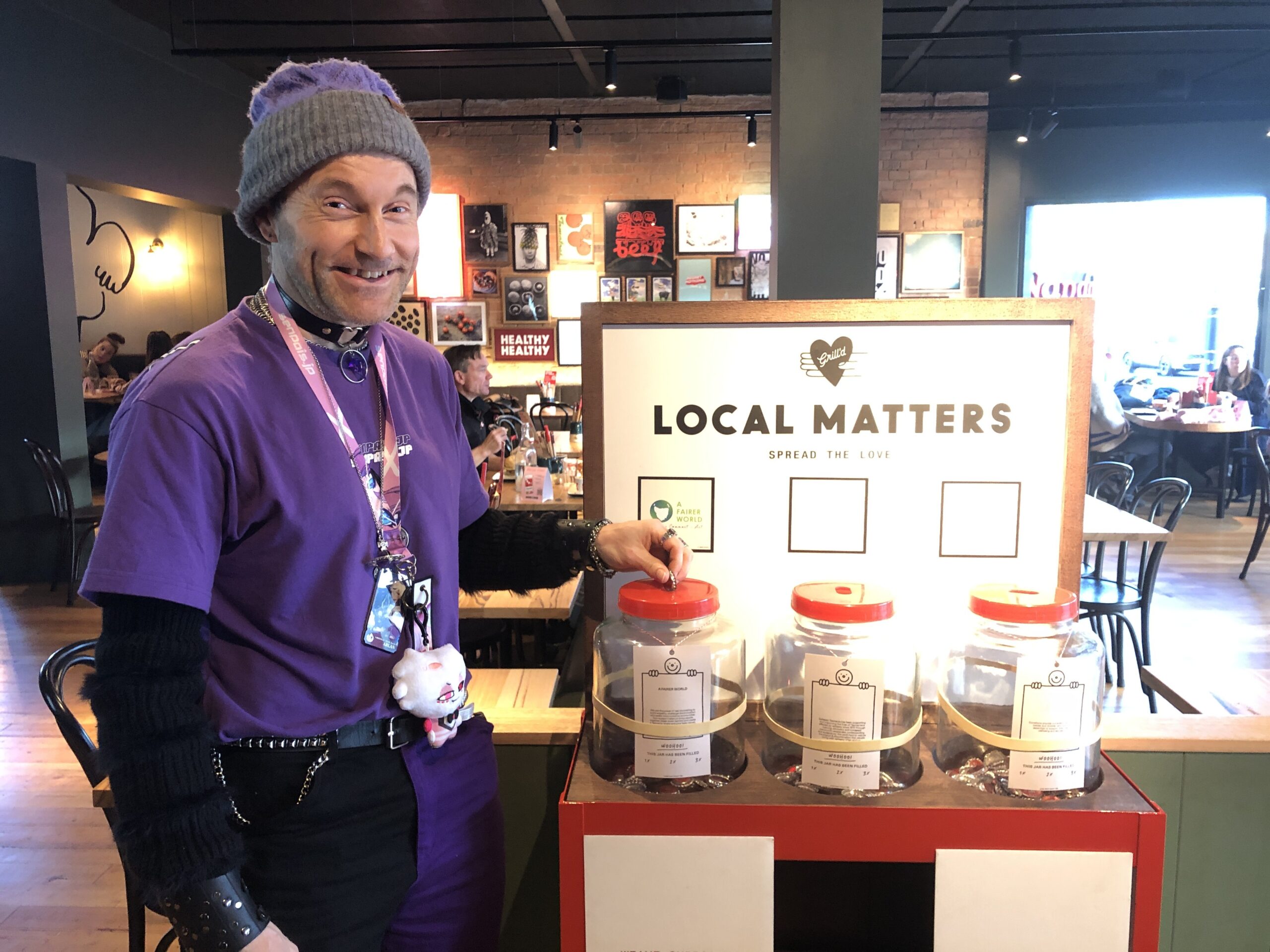 Human 'book' Josh placing his token vote into the A Fairer World Jar at Grilld in North Hobart