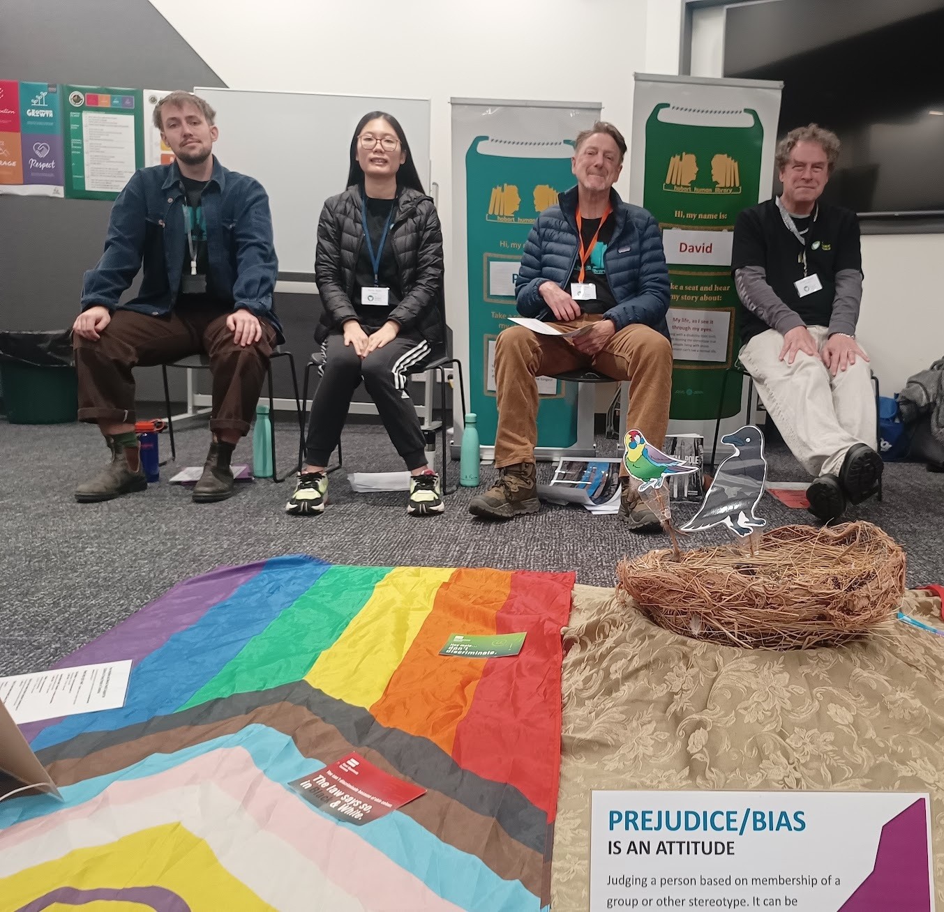 A Fairer World staff with human 'books' Jasper, Katie, Paul and David prepareing for the next session with flags and engaging props in the foreground.